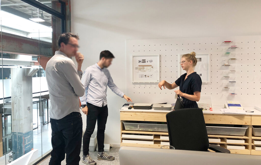 three people standing having a brainstorm together.